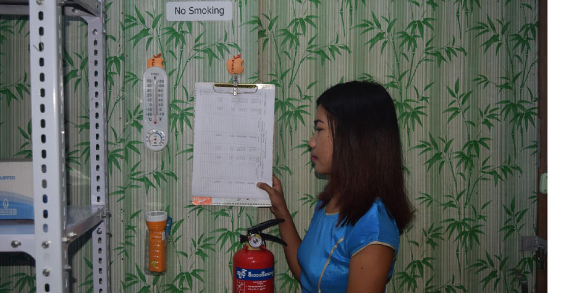 At Pyi Gyi Khin drug store, a thermometer and temperature chart are used to record and monitor temperature for the optimal storage of drugs. A fire extinguisher is easily accessible. Pyi Gyi Khin, Pakokku Township At Pyi Gyi Khin drug store, a thermometer and temperature chart are used to record and monitor temperature for the optimal storage of drugs. A fire extinguisher is easily accessible. Pyi Gyi Khin, Pakokku Township