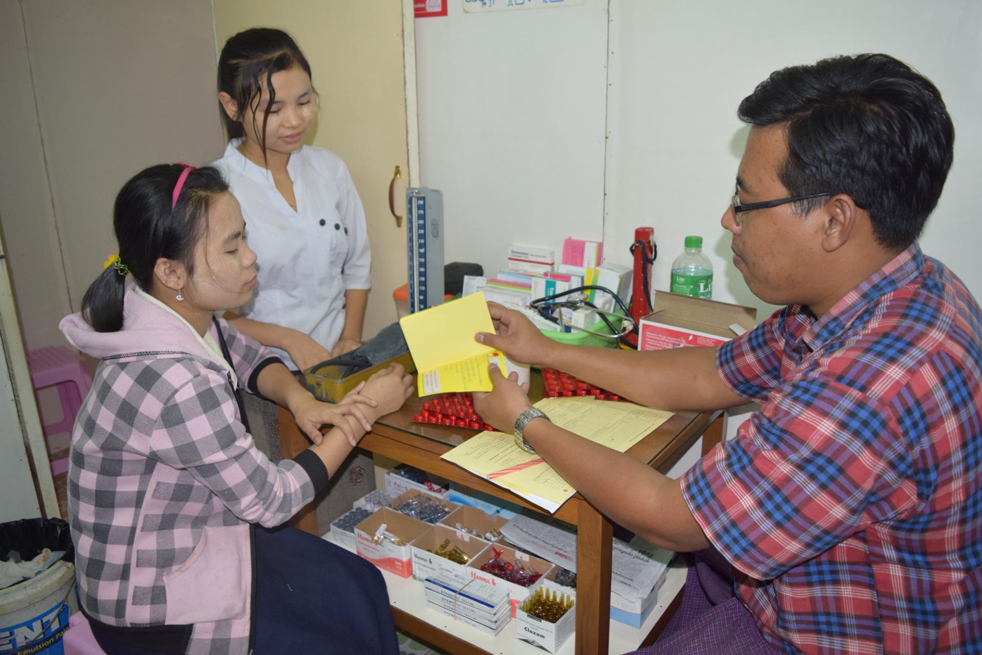 Dr Lin Htoo Lwin provides advice on compliance to taking anti-TB drugs while he dispenses drugs at his private clinic in Shwe Pyi Thar Township, Yangon. Photo: MMA