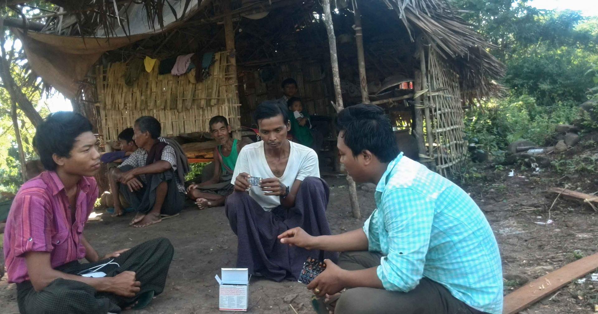 During a visit to Ko Win Zaw’s home, Ko Nay Linn checks anti-TB medicines to confirm he is taking the correct doses. Incorrect doses could delay his recovery and give rise to drug resistance. Photo: MHAA