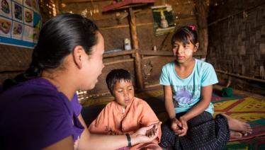A caregiver from Pyi Gyi Khin conducts home visits to help ensure that nutritional and psychosocial support is provided.  Lwai Hat village, Aung Ban Township, Southern Shan State. Photo: John Rae/The Global Fund