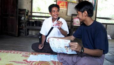 Ko Kyaw Kyaw Myint reassures Ko Han Min Htun who is about to have a month-2 sputum check- up for tuberculosis. Volunteers are always on hand to help patients once they have received their test results. Tharzi township, Mandalay Region. Photo: UNOPS